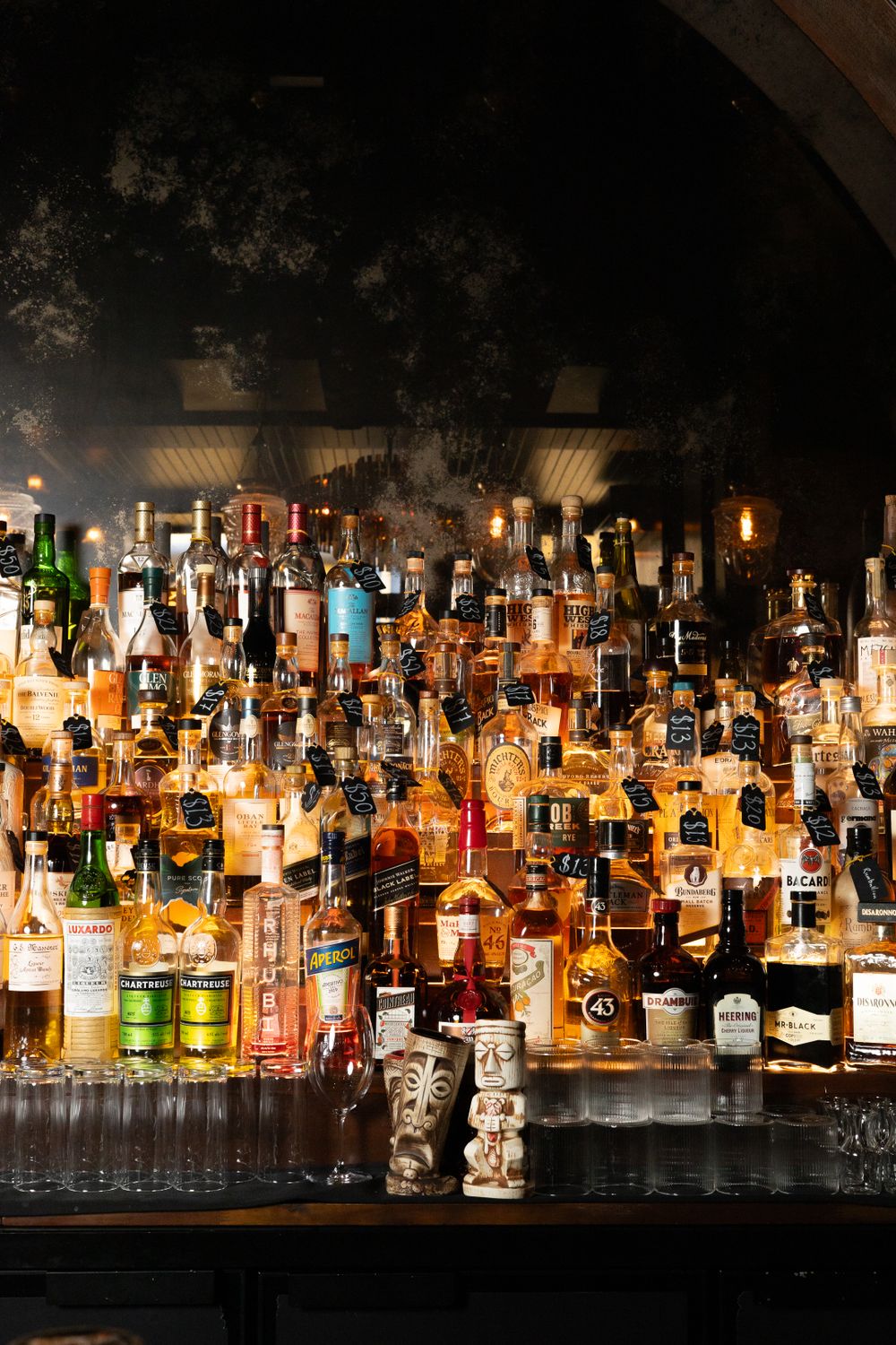Extensive collection of backlit liquor bottles displayed on illuminated bar shelves.