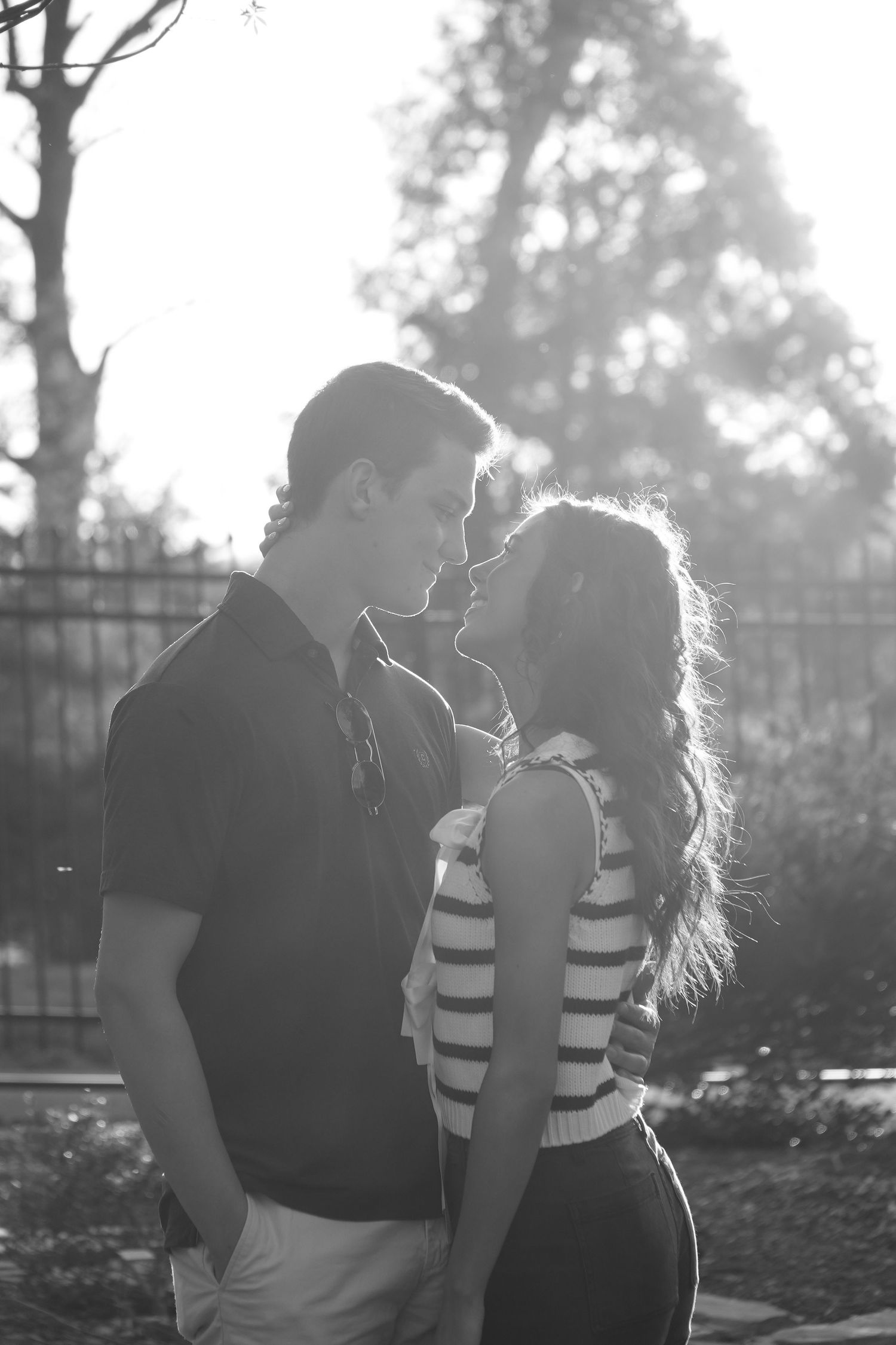 Black and white backlit portrait session creating dramatic silhouettes in natural setting.