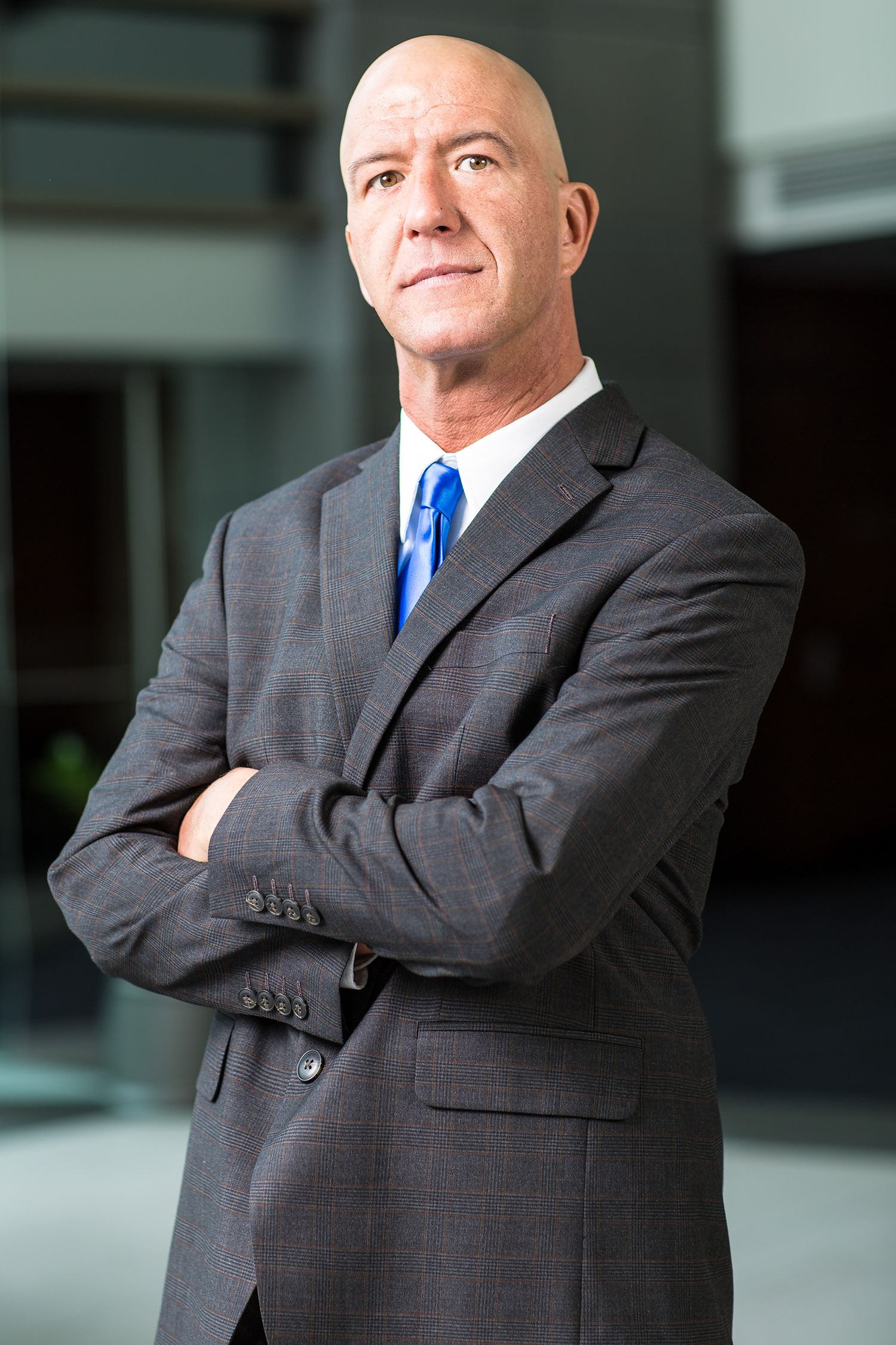 Businessman with a serious expression, wearing a navy blazer and white shirt, photographed allianz