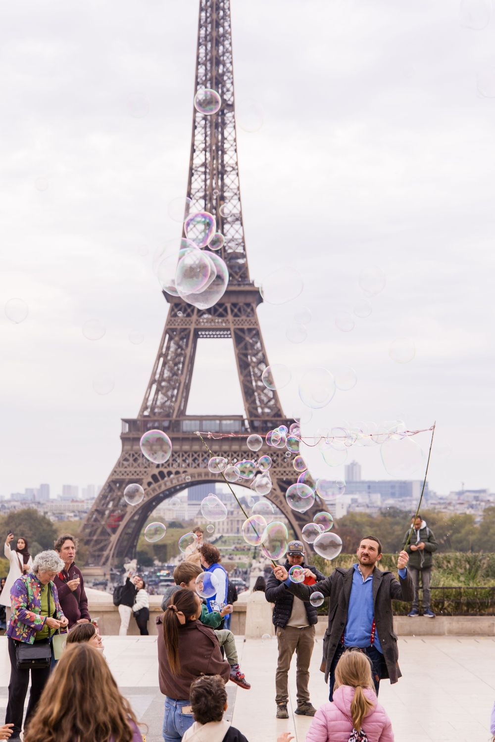 Street performer making bubbles near the Eiffel Tower in Paris.