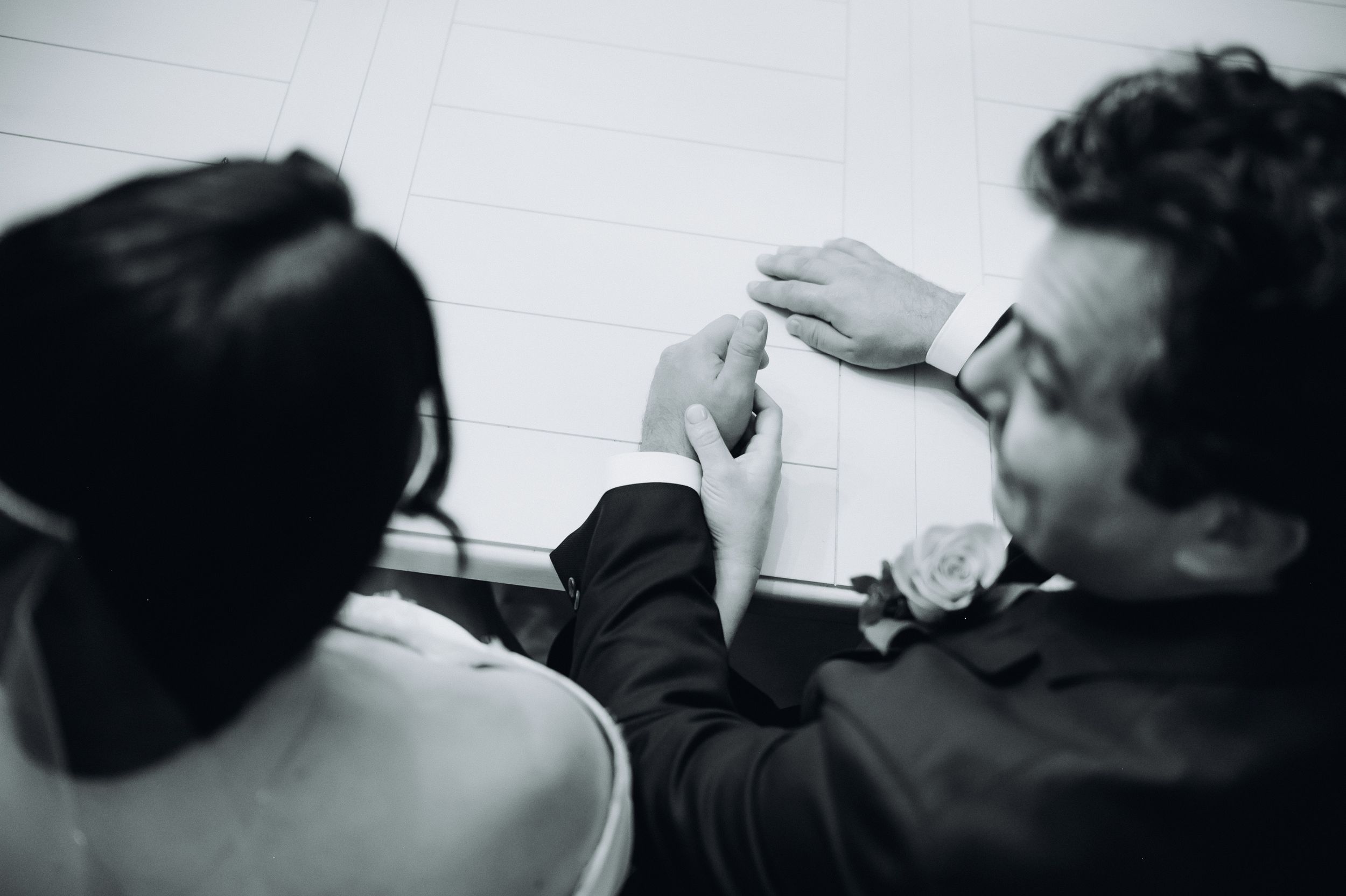 Black and white image of a couple sitting together and sharing an intimate moment during Ketubah.
