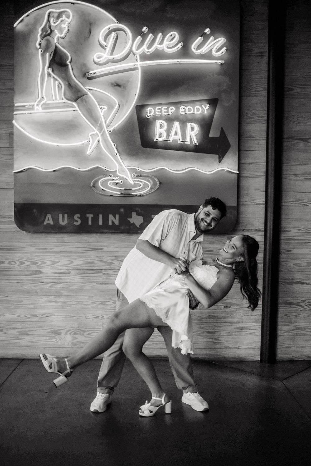 Retro neon signs illuminate a bar wall with vintage-style decorative elements.