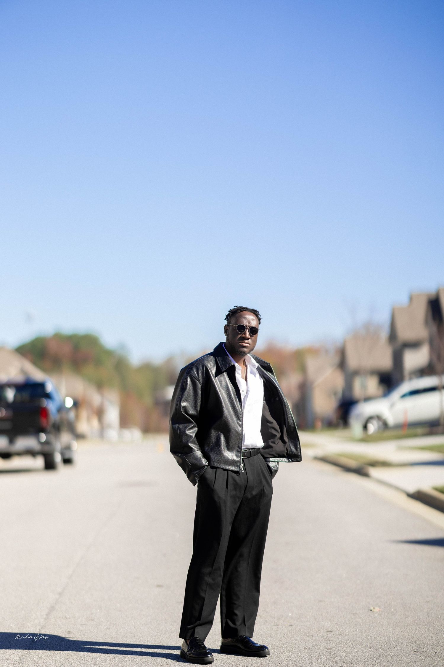 A sequence of photos showing a person in a dark coat walking on a suburban street on a sunny day.