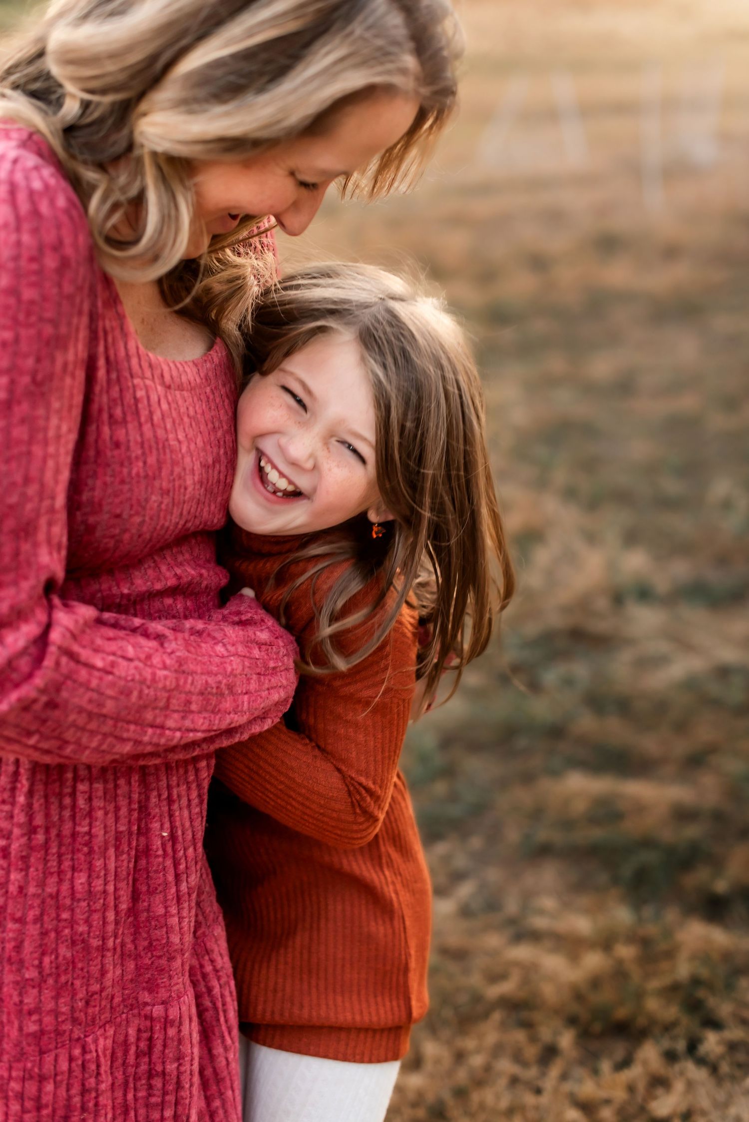 Sweet candid moment of laughter and embracing in warm autumn light.