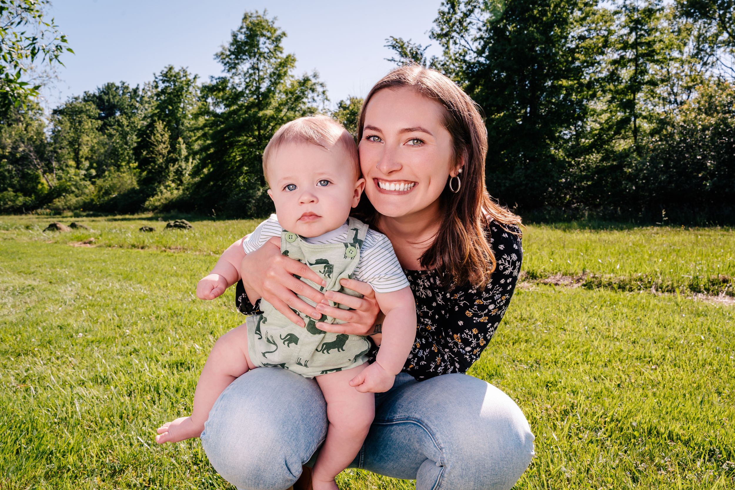Mother and baby enjoying a sunny day together on green grass outdoors.