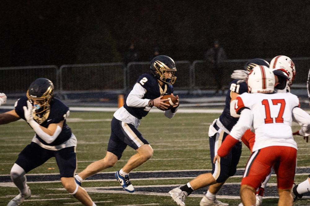 Football players from opposing teams in action during a night game at George Fox University.