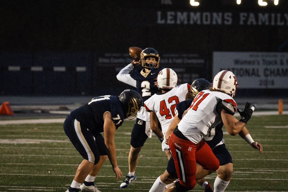 Football players from two teams facing off on the field under stadium lights at George Fox University.