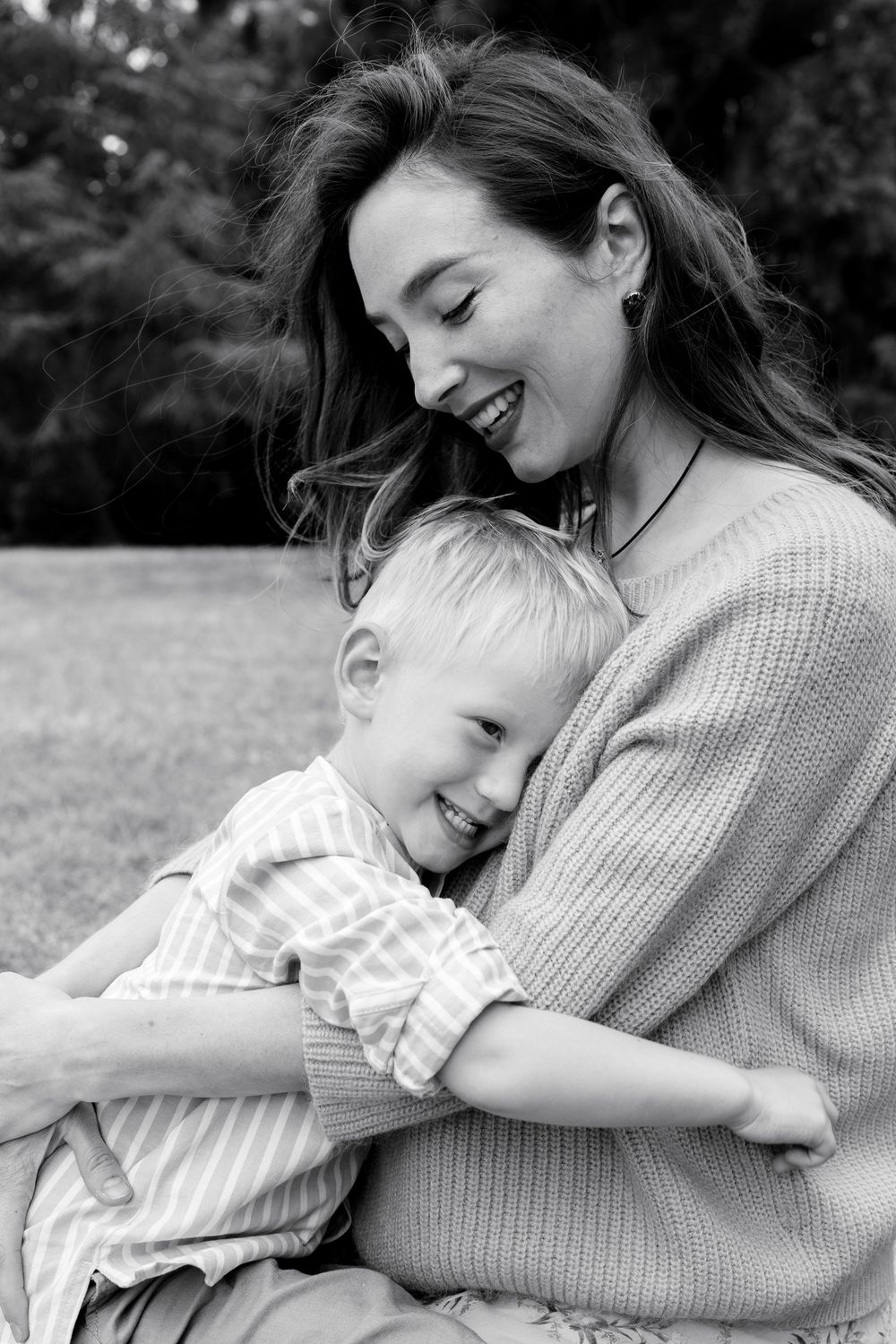 A heartwarming black and white portrait showing a tender moment of embrace between parent and child. London UK