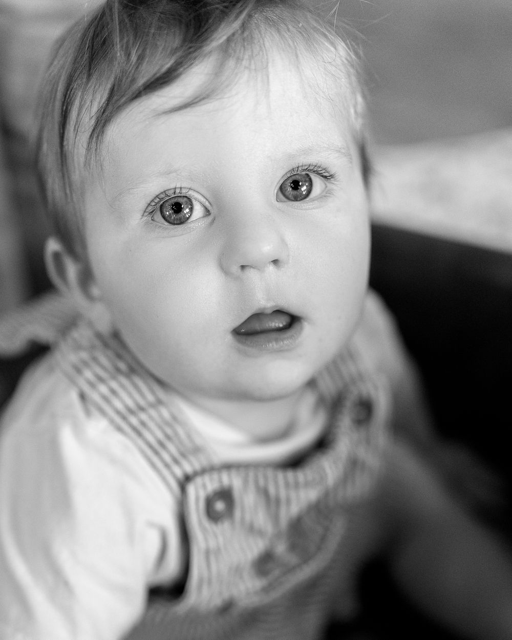 Black and white portrait showing close-up expressions and details of a young child's face captured in Ely, UK