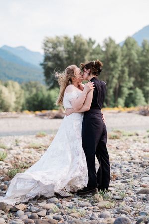 Two brides kiss during their windy elopement in Ashford, Washington.