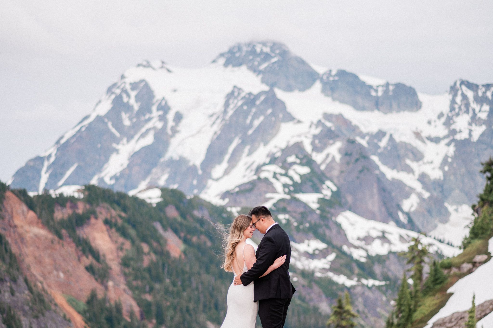 Bride and groom embracing at Artist Point with snowy mountain behind them during their North Cascades elopement.