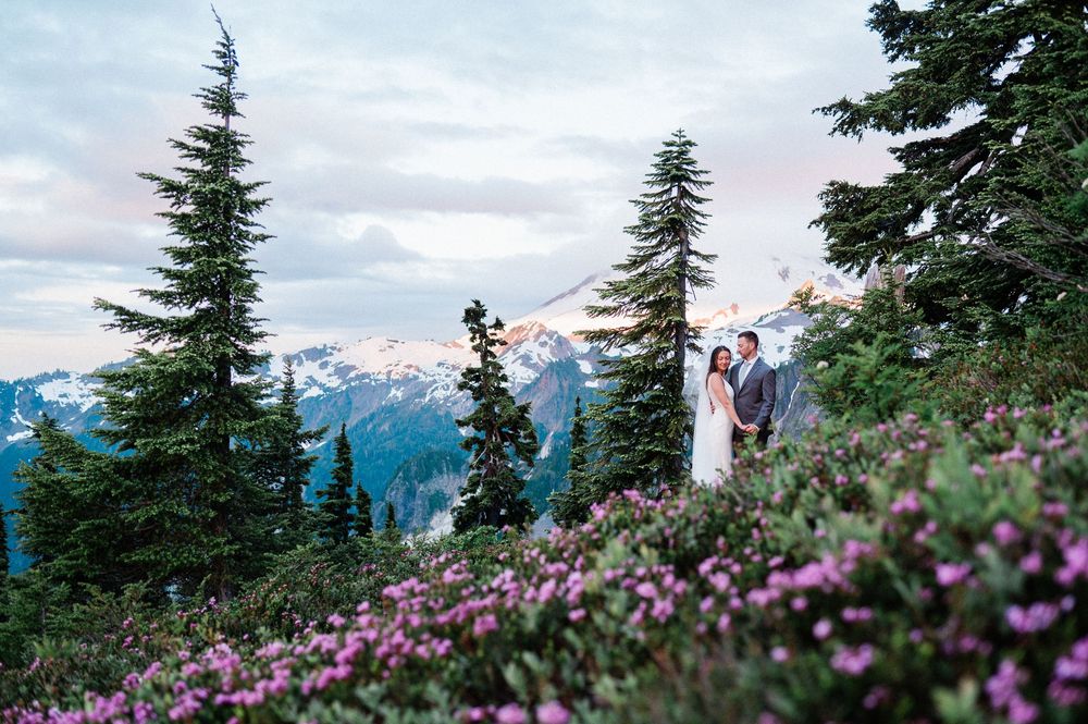 bride and groom during their Mt Baker elopement at sunrise surrounded by pink flowers