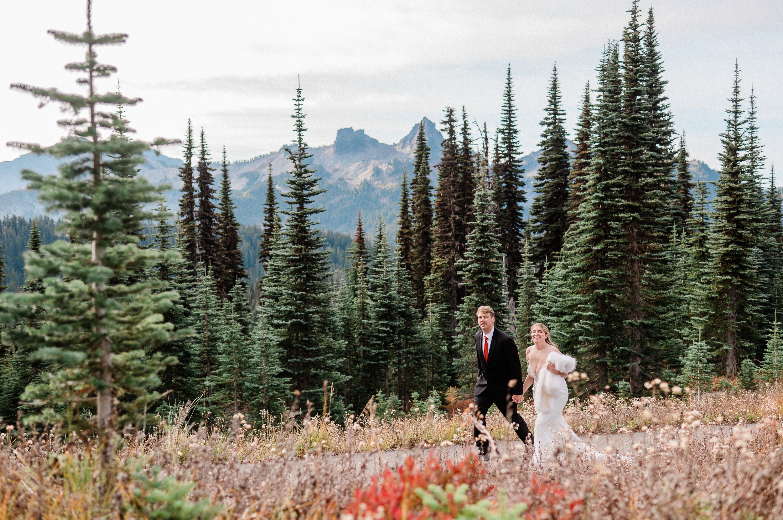 bride and groom walking hand in hand during fall Mt. Rainier elopement.