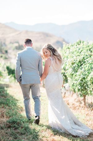Bride and Groom walking in vineyard at Lake Chelan. Photo by Pine + Vow.