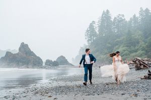 Bride and Groom running along coast at Ruby Beach. Photo by Washington Elopement Photographer, Pine + Vow.