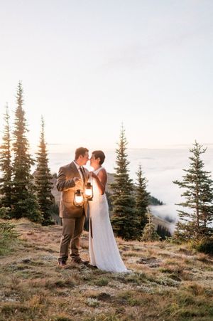 Bride and Groom holding lanterns at sunset in Olympic National Park. Photo by Pine + Vow.