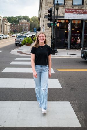 High school senior girl posing confidently in a downtown alley with brick walls and city textures – urban senior portrait in Twin Cities MN