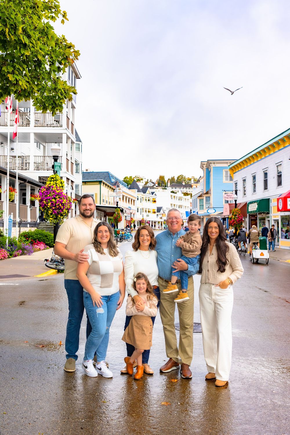 Group walking together on a beachfront boardwalk on a cloudy day in a coastal town.