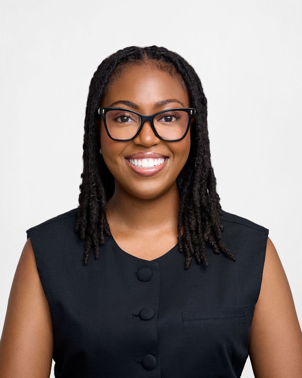 Professional headshots showing person in black sleeveless top with glasses and braided hair smiling warmly against light background.