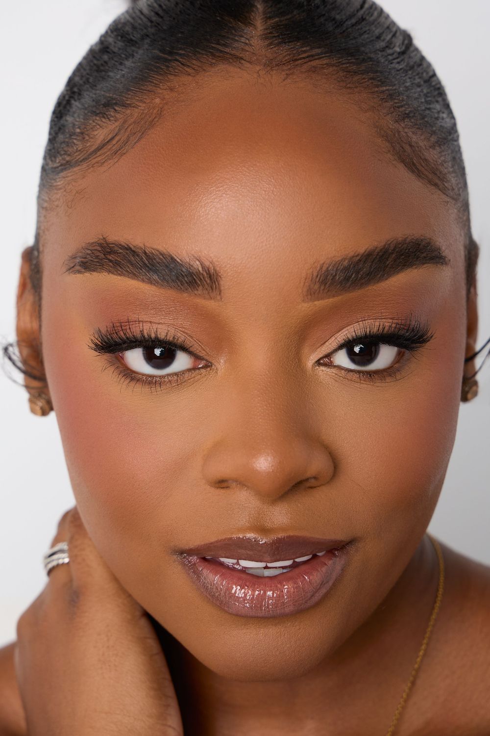 Close-up beauty portrait showcasing flawless makeup and natural glam look.