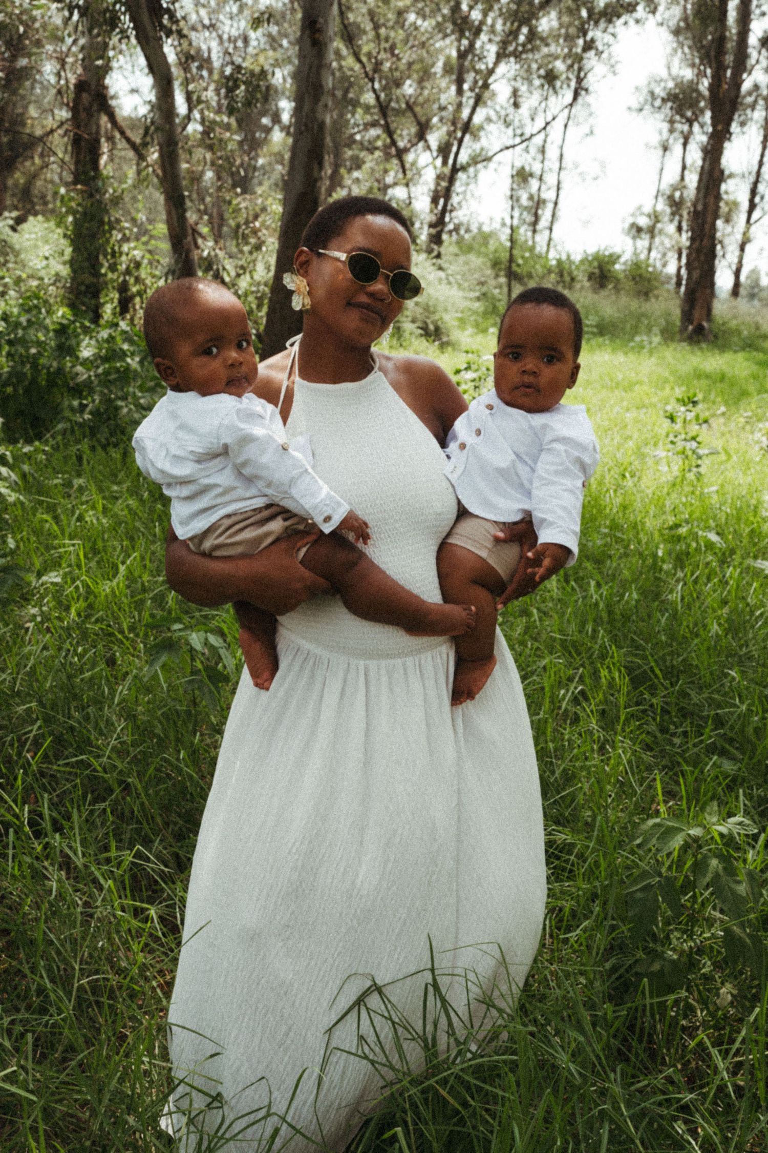 Family portrait series captured in natural outdoor setting with tall grass and trees.