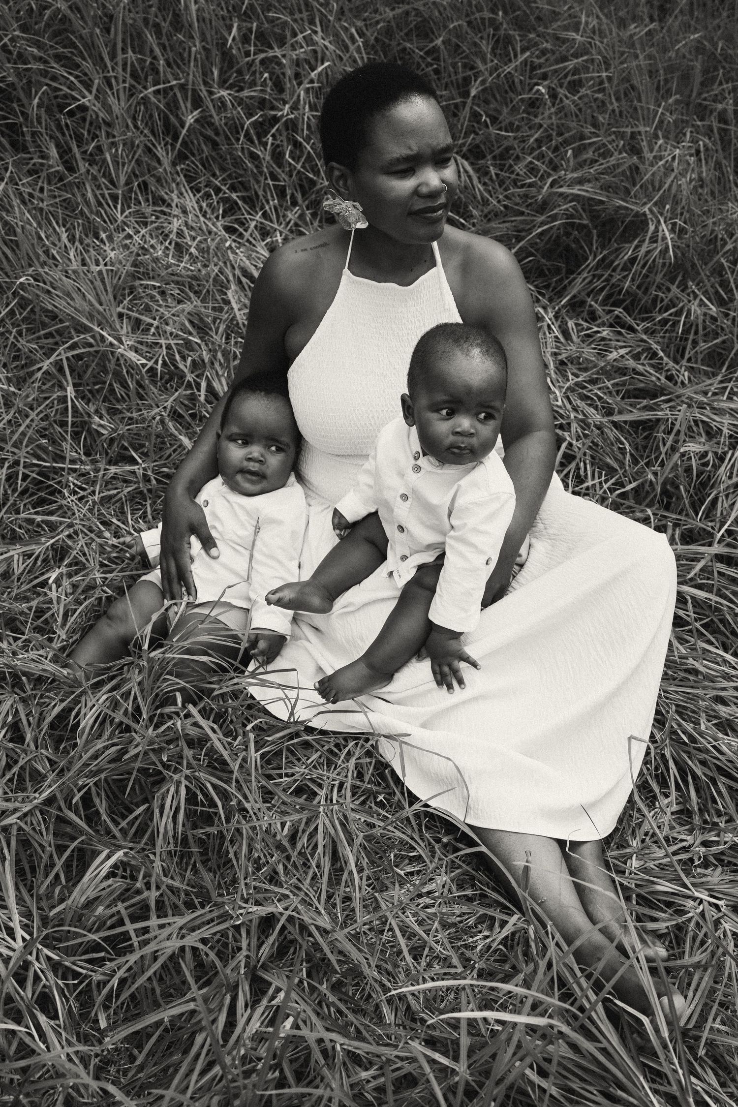 Black and white portrait of family members sitting together outdoors.