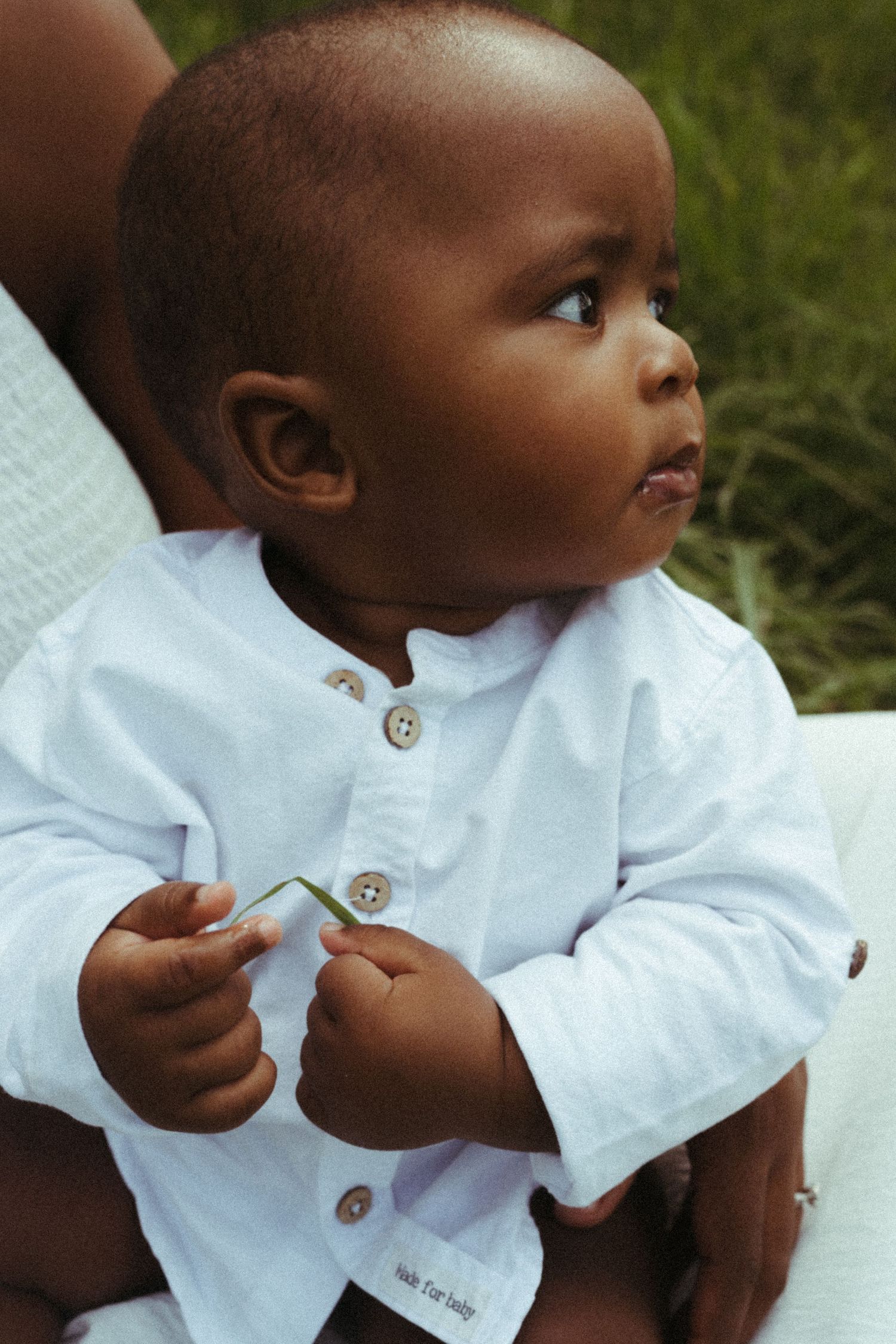 Close-up detail of white collared shirt on small child during outdoor shoot.
