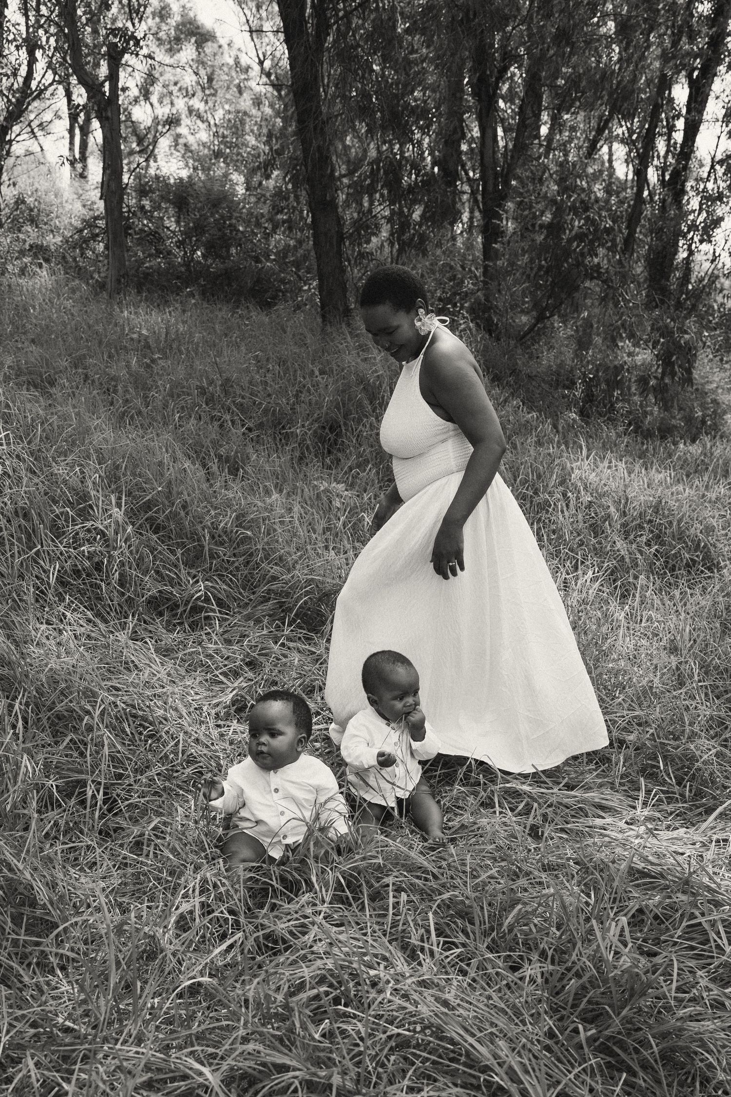 Black and white photo of family bonding moment in outdoor natural setting.
