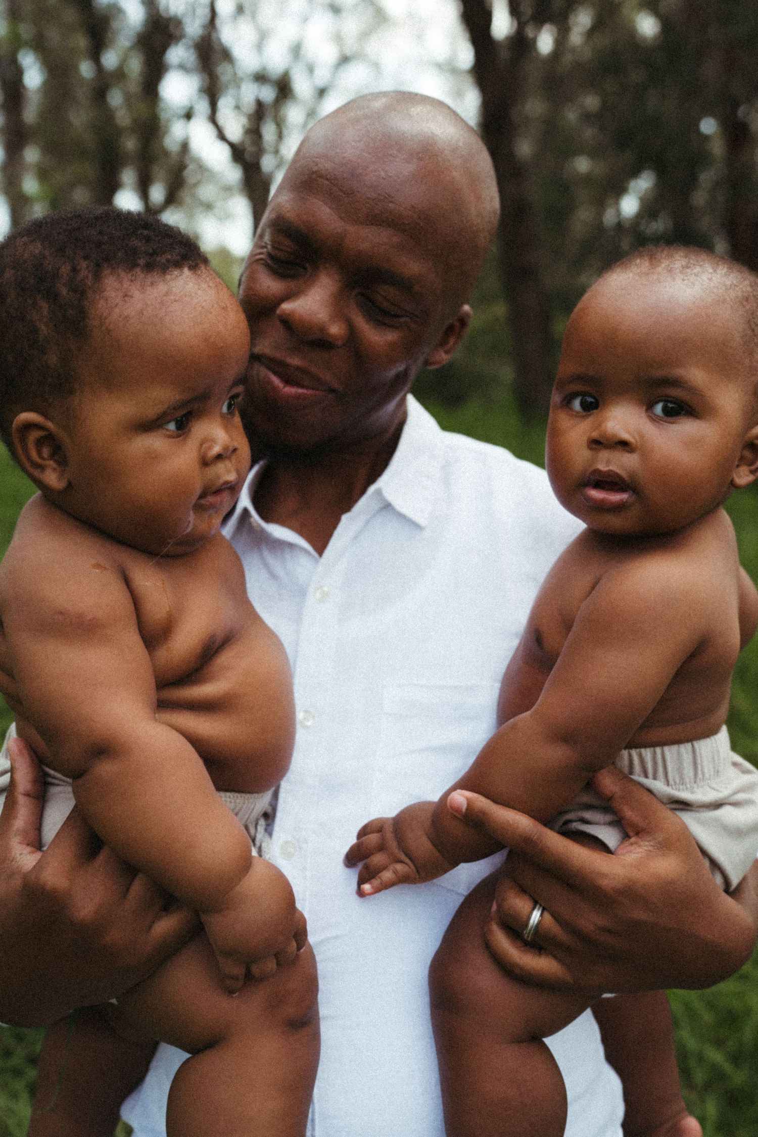 Candid shots of baby being held against white shirt in outdoor setting.