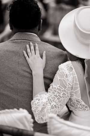 Close-up of intricate lace detail on wedding dress shown in black and white photography.