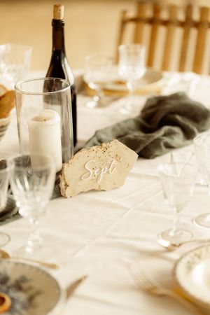 Elegant wedding reception table setting with wine glasses and candlelight on white tablecloth.