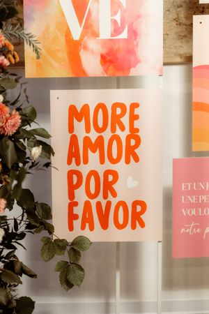 Four decorative signs with orange and pink gradient text reading 'MORE', 'AMOR', and 'POR FAVOR' against white backgrounds.