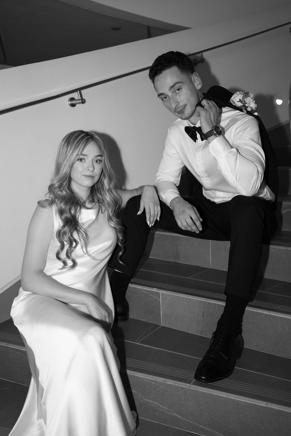 Black and white artistic photo series showing a couple in formal attire posing on stairs in various romantic poses.