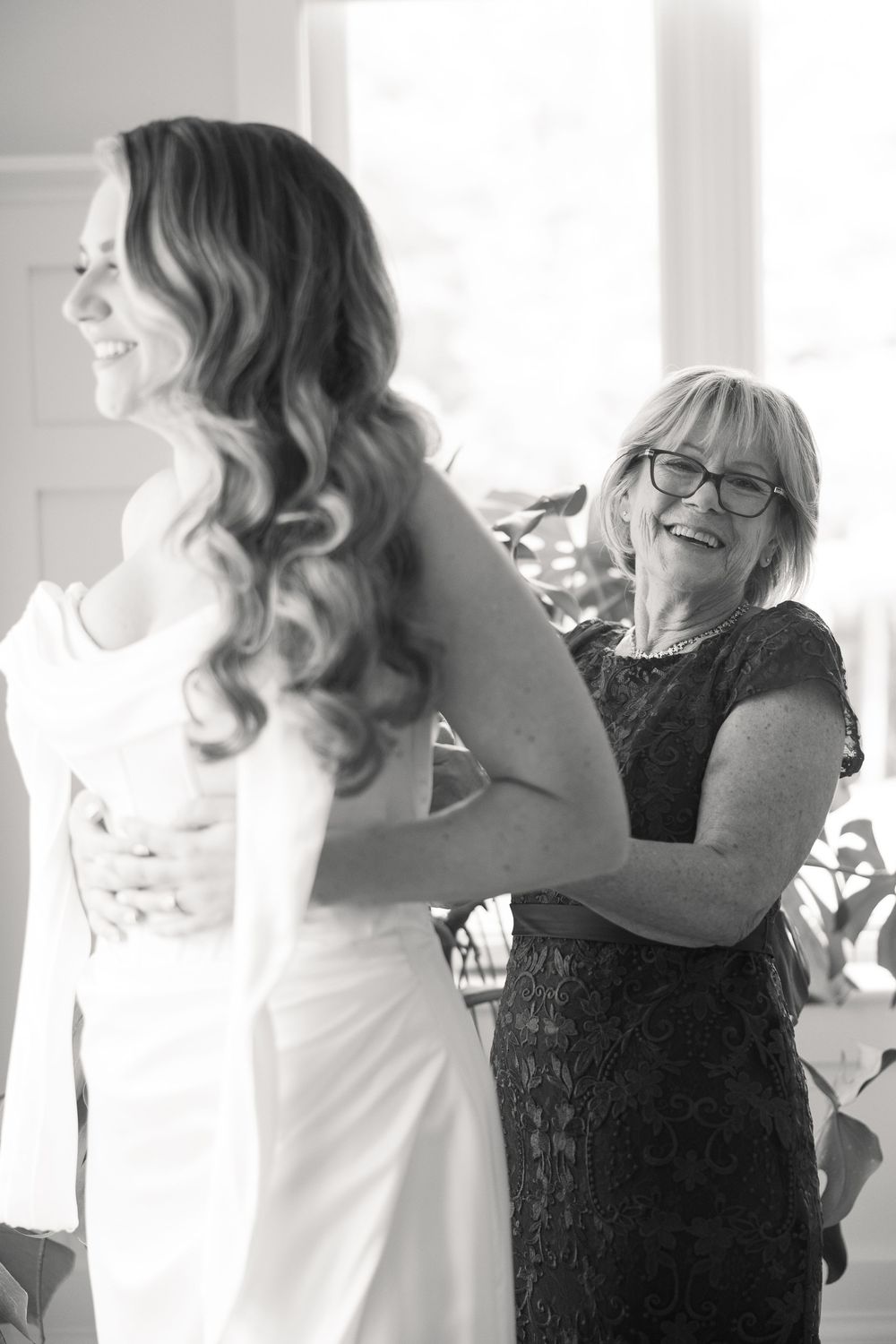 Black and white photo series showing joyful candid moments between two people in formal attire.