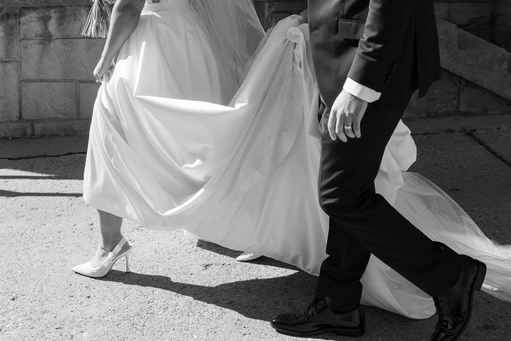 A series of black and white wedding photos showing feet and dress details during a ceremony.