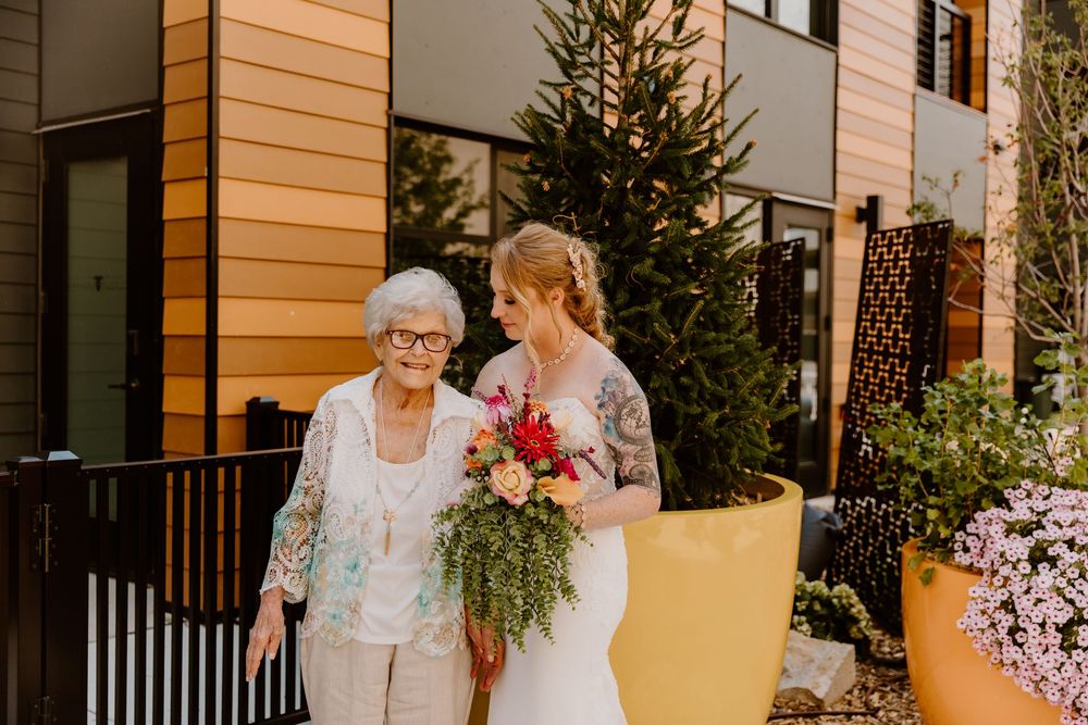 Outdoor wedding portraits with modern architecture and greenery in the background.