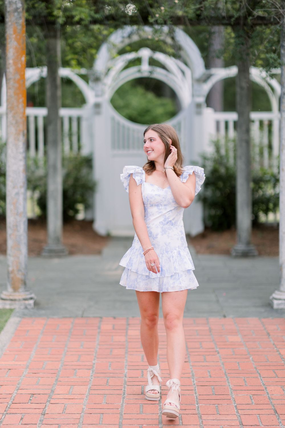 Playful poses on brick pavement with white architectural columns in the background.