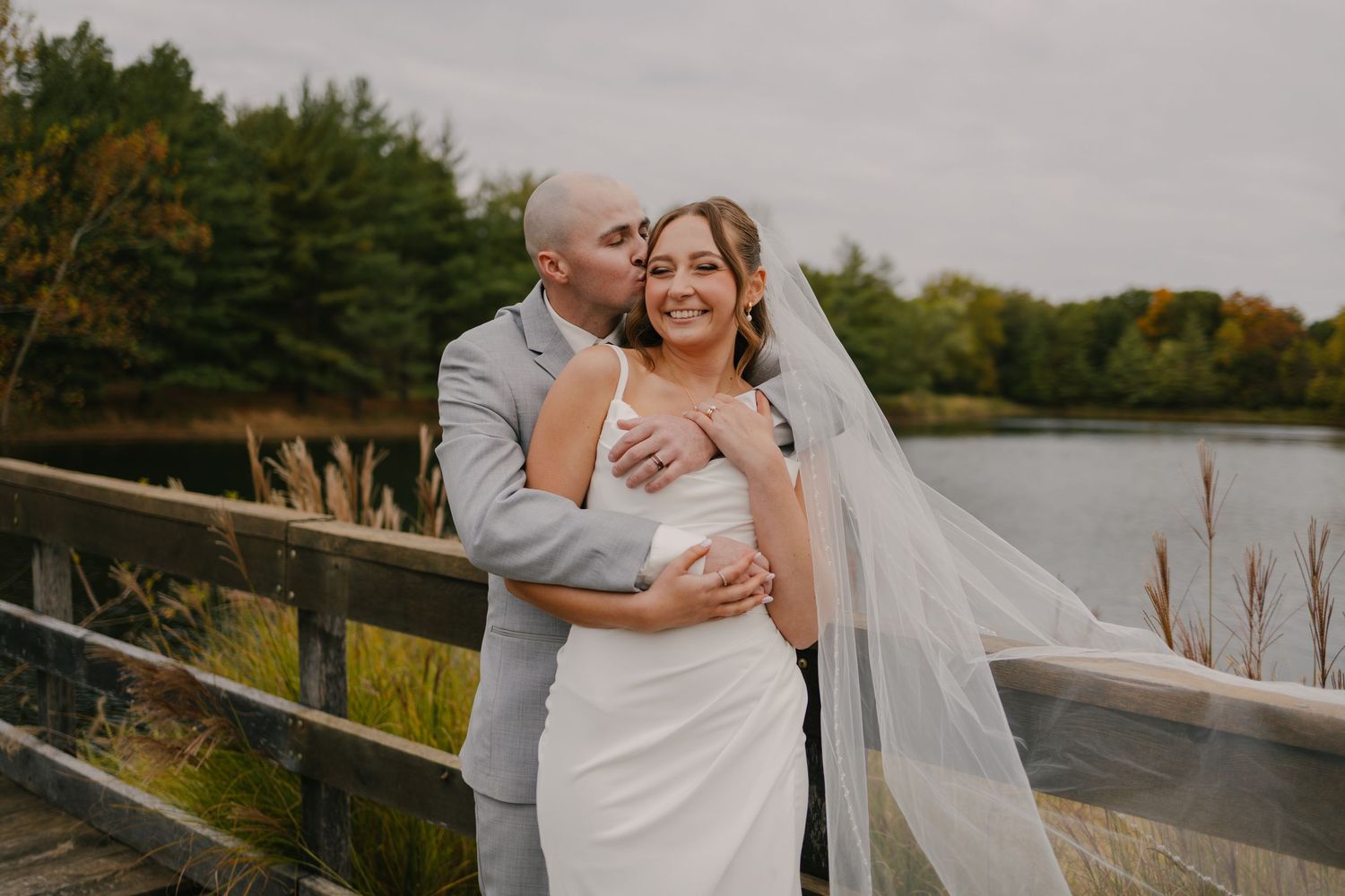 A romantic sunset portrait of newlyweds by a waterfront.