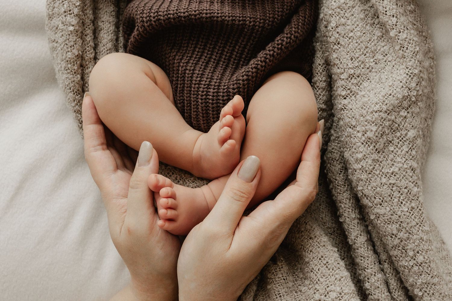 Detailaufnahme von Babyfüßen in den Händen der Mutter bei einem Newbornshooting Stockerau