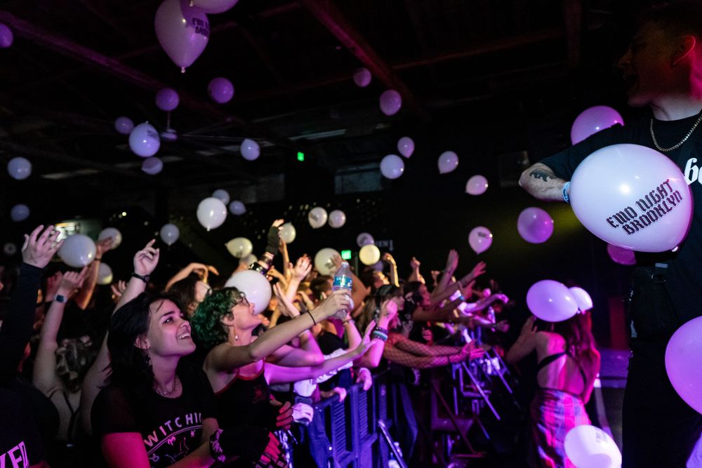 Nightclub scene with purple lighting and floating balloons creating an energetic atmosphere.