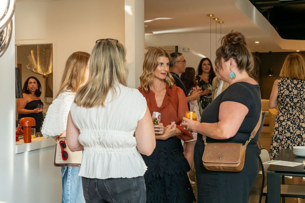 Bright modern event space with people gathered for a social occasion.