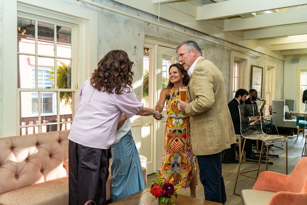 Group gathering in a bright office space with colorful floral arrangements.