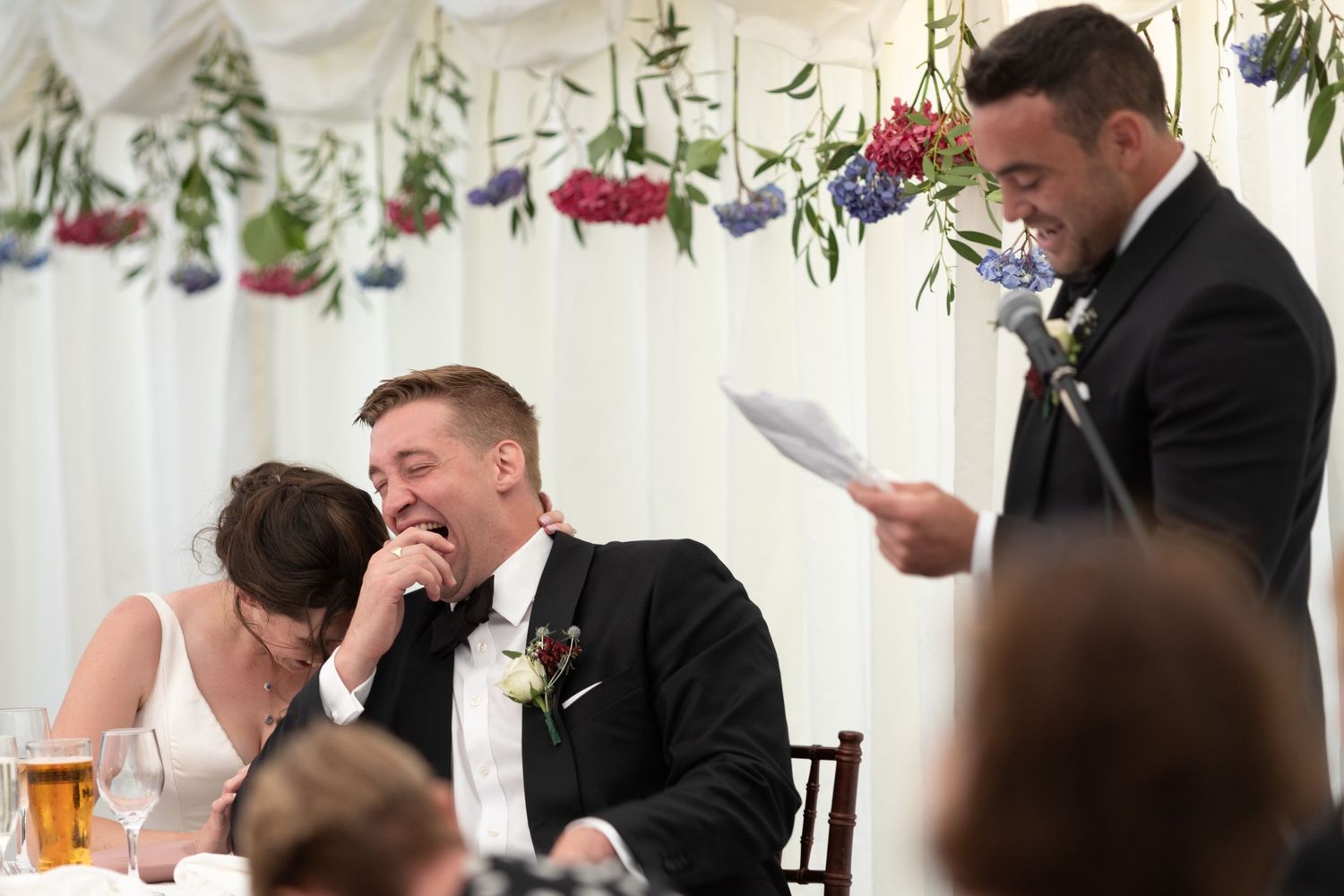 Bride and groom with best man during wedding speeches