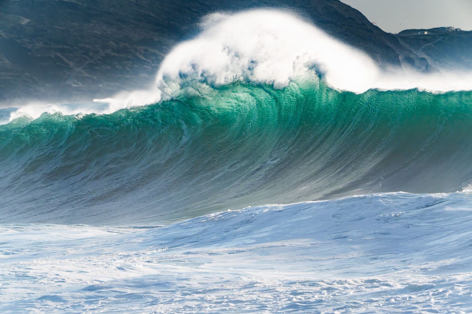 Massive turquoise ocean wave crests and breaks with white foam in dramatic seascape sequence.