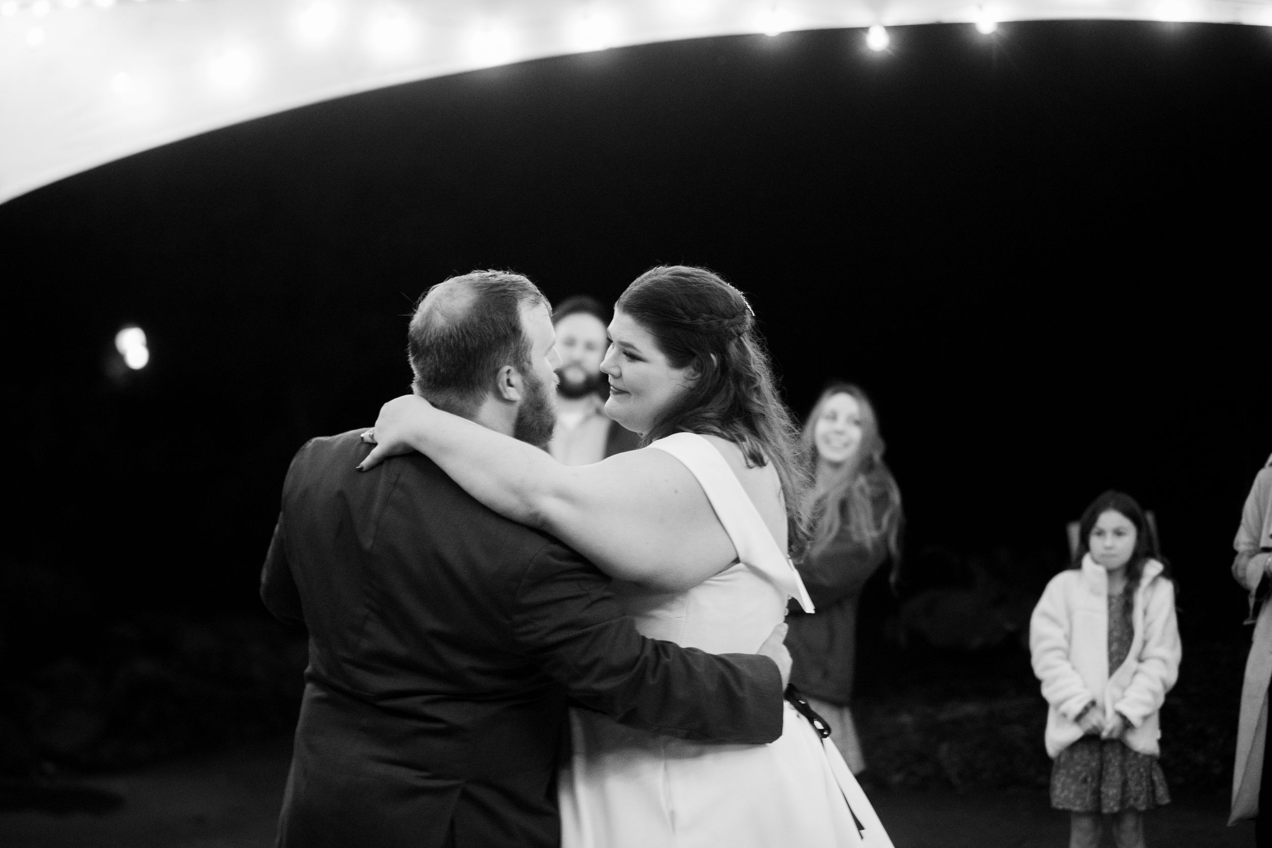 Black and white photo of a couple's first dance at their wedding reception.