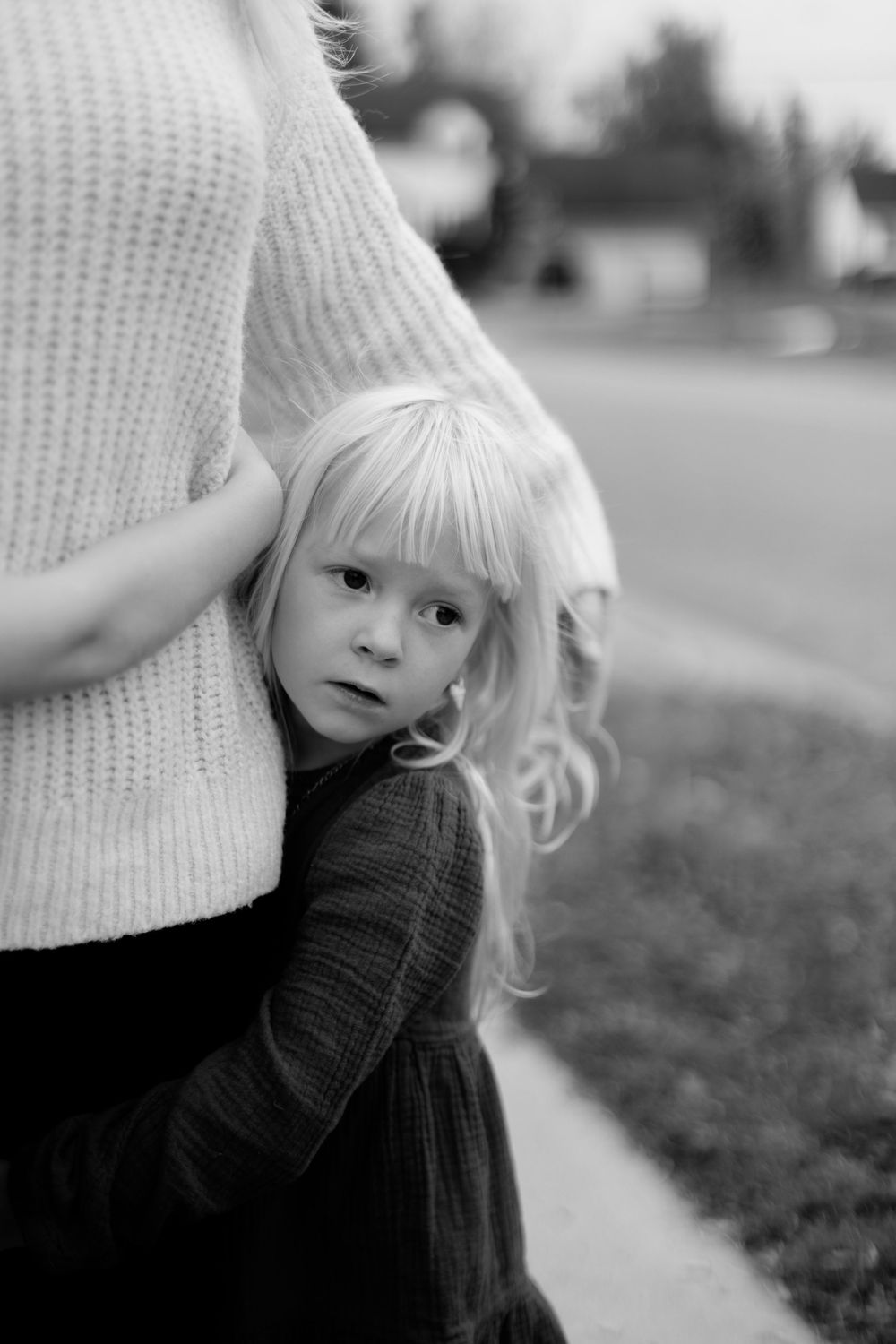 A series of black and white photos showing a child with light hair wearing a dark sweater looking to the side.