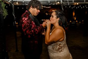 A couple shares an intimate dance moment under warm lighting at an evening reception.