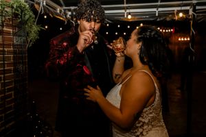 A couple embraces while dancing at a dimly lit wedding reception.