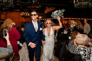 First dance moment in rustic venue with elegant lighting and head table in background.