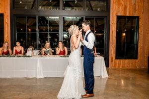 Playful cake-feeding moment between couple at wedding reception.